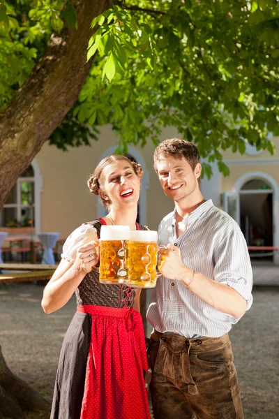 Koppel met bier stein en traditionele kleding — Stockfoto