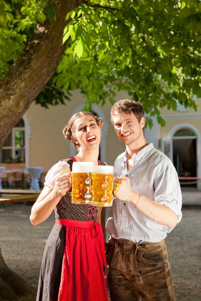 Coppia con birra stein e abiti tradizionali — Foto Stock