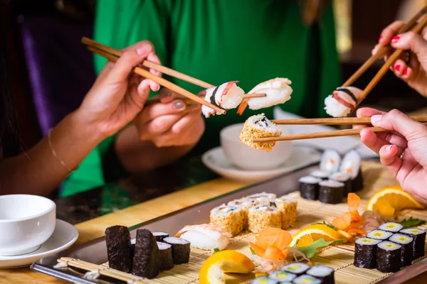 Молодые люди едят суши в азиатском ресторане — стоковое фото