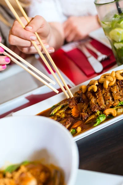 Junge Leute essen Essen im thailändischen Restaurant — Stockfoto