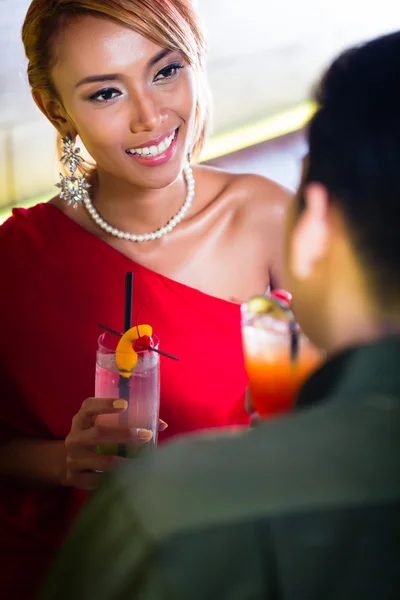 Азиатская пара пьет коктейли в баре — стоковое фото
