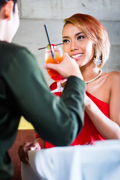 Asiatisches Paar trinkt Cocktails in Bar — Stockfoto