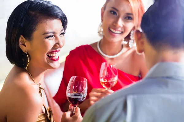 Азиатские друзья пьют вино в модном баре — стоковое фото