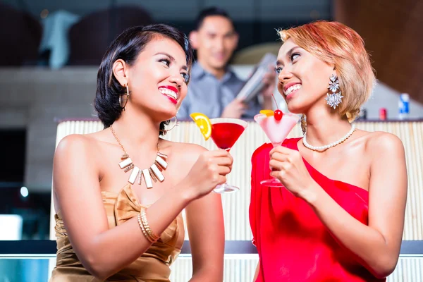 Asiatische Frauen trinken Cocktails in schicker Bar — Stockfoto