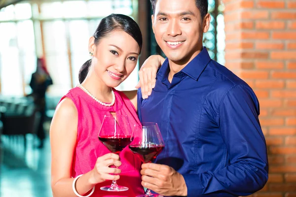 Aziatische paar met glas rode wijn — Stockfoto