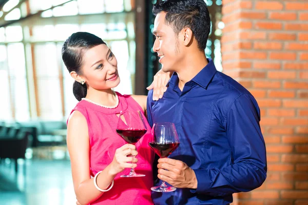 Asian couple with glass of red wine — Stock Photo, Image