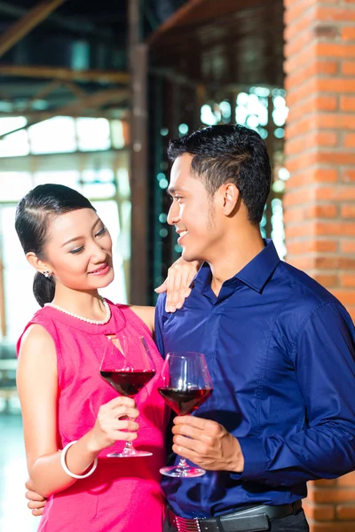 Casal asiático com copo de vinho tinto — Fotografia de Stock