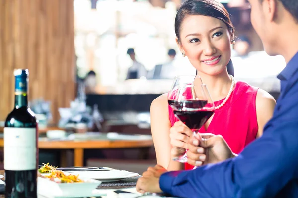 Asiatisches Paar mit Wein im Restaurant — Stockfoto