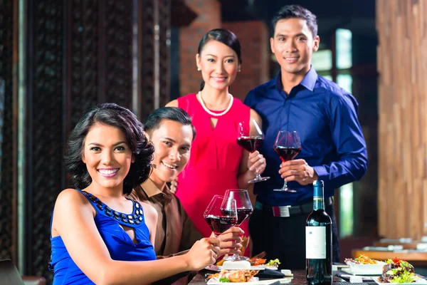 Ασίας οι φίλοι φρυγανίσματος με κρασί στο εστιατόριο — Φωτογραφία Αρχείου