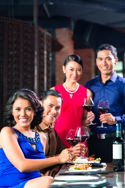 Asian Friends toasting with wine in restaurant — Stock Photo, Image
