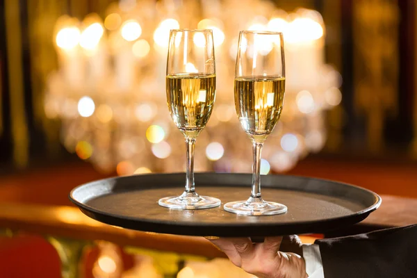 Pincér pezsgőspoharak tálca étteremben szolgálják fel — Stock Fotó