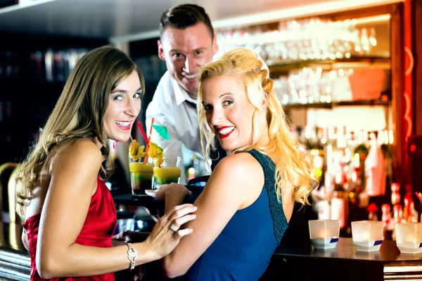 Junge Frauen und Barkeeper in Club oder Bar — Stockfoto