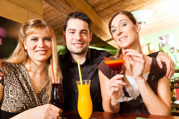 People drinking cocktails in bar or restaurant — Stockfoto