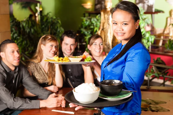 People with waitress eating in Thai restaurant — Stock fotografie