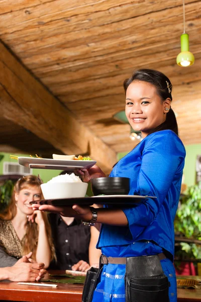 People with waitress eating in Thai restaurant — Stock Photo, Image