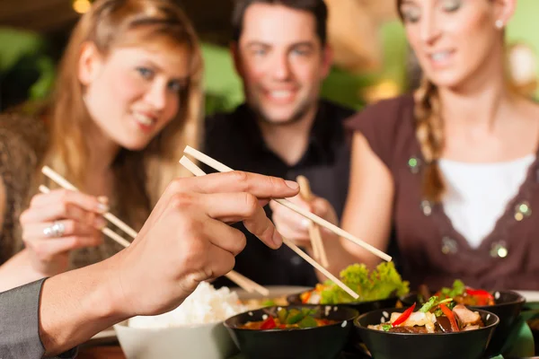 Young people eating in Thai restaurant — Stock Photo, Image