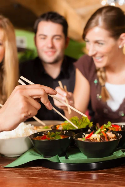 Young people eating in Thai restaurant — Stock Photo, Image