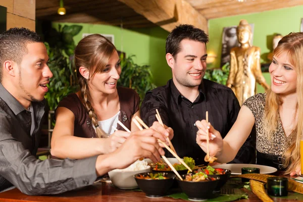 Jóvenes comiendo en restaurante tailandés — Foto de Stock