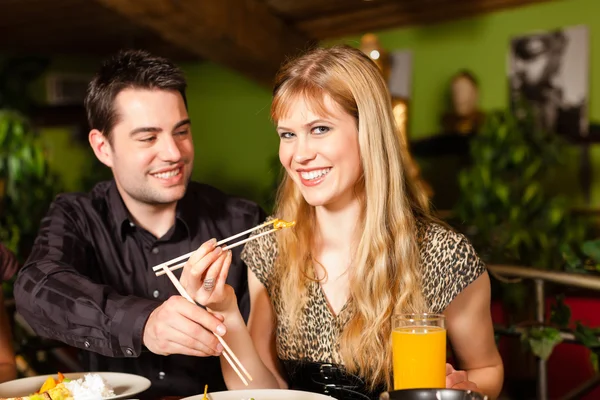 Young people eating in Thai restaurant — Stock Photo, Image