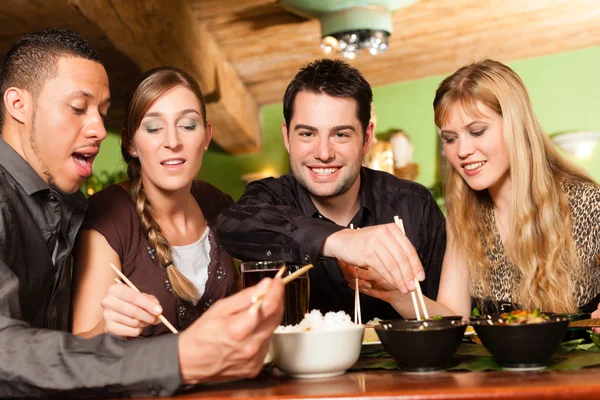 Jóvenes comiendo en restaurante tailandés — Foto de Stock