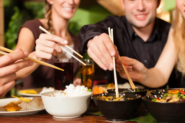 Young people eating in Thai restaurant — Stock Photo, Image