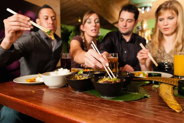 Jóvenes comiendo en restaurante tailandés —  Fotos de Stock