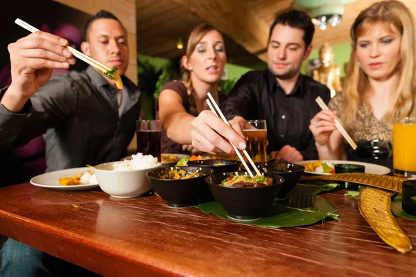 Jóvenes comiendo en restaurante tailandés — Foto de Stock