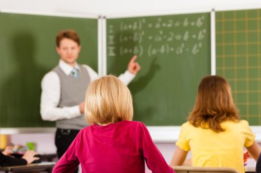 Education - Teacher with pupils in school teaching