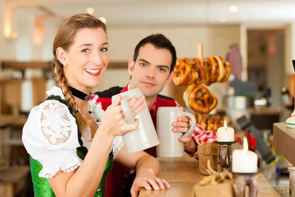 Casal jovem em Tracht tradicional da Baviera em restaurante ou pub — Fotografia de Stock