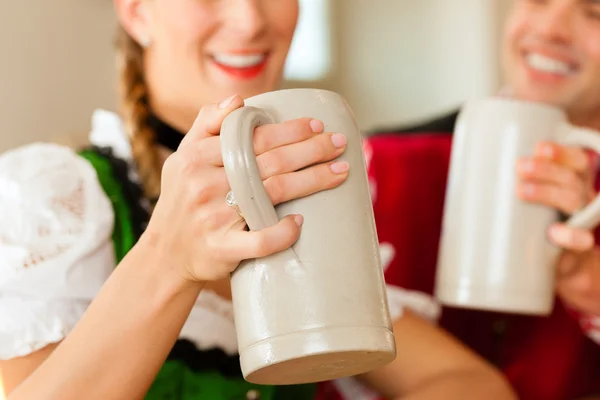 Junges Paar in traditioneller bayerischer Tracht in Restaurant oder Kneipe — Stockfoto