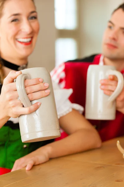 Parejas jóvenes en tradicional Bavarian Tracht en restaurante o pub —  Fotos de Stock