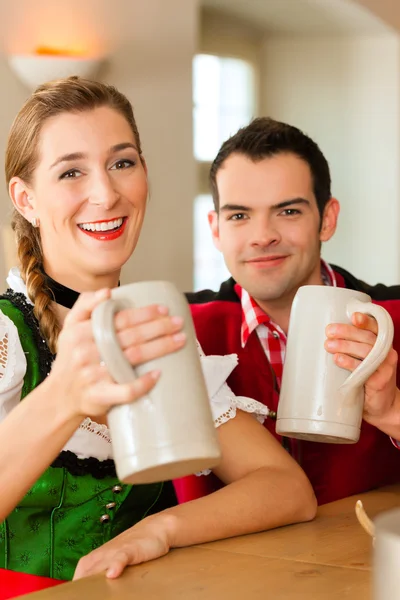 Parejas jóvenes en tradicional Bavarian Tracht en restaurante o pub —  Fotos de Stock