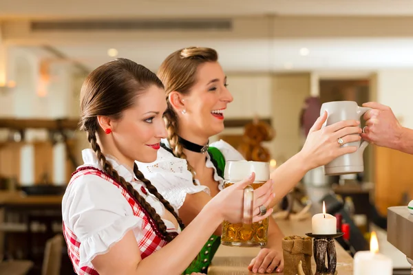 Women in traditional Bavarian Tracht in restaurant or pub — Stok fotoğraf