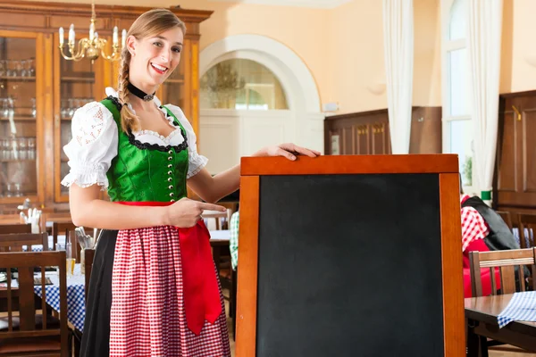 Femme aubergiste en vêtements bavarois traditionnels dans un pub — Photo