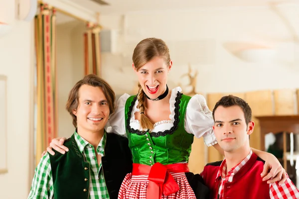 People in traditional Bavarian Tracht in restaurant or pub — стокове фото