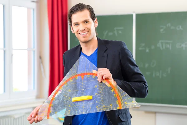 Lehrer mit Dreieck vor einer Schulklasse — Stockfoto