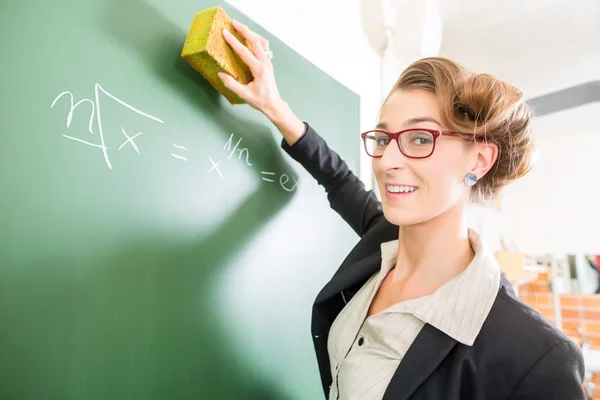 Lehrer mit Schwamm vor einer Schulklasse — Stockfoto