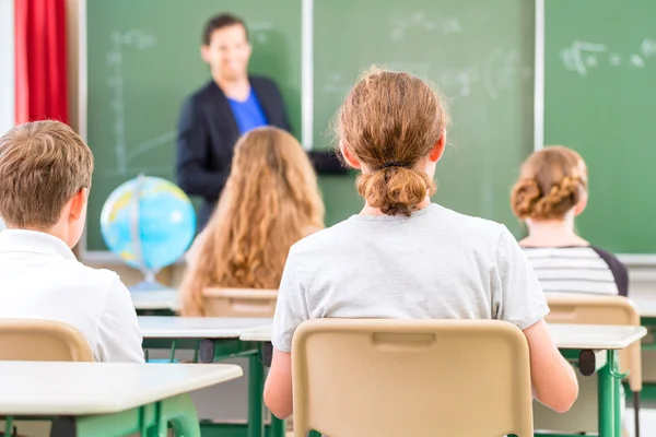 Lehrer unterrichten oder unterrichten am Brett eine Klasse in der Schule — Stockfoto