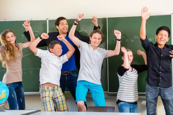Teacher motivating students in school class — Stock Photo, Image