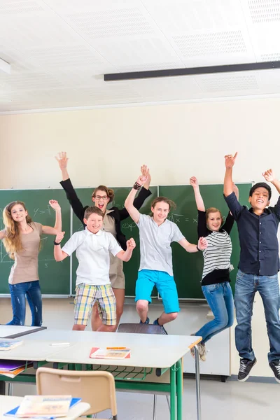 Professora que motiva os alunos na sala de aula — Fotografia de Stock