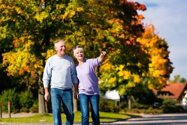 Senioren im Herbst oder Herbst gehen Hand in Hand — Stockfoto