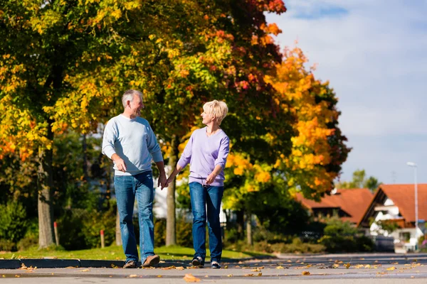 Idősek az ősz és őszi séta kéz a kézben — Stock Fotó