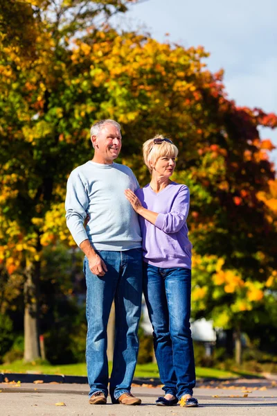 Senioren im Herbst oder Herbst gehen Hand in Hand — Stockfoto