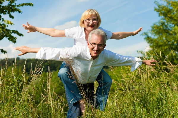 Счастливая пожилая пара весело проводит лето на свежем воздухе — стоковое фото