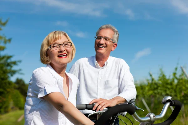 Happy couple cycling outdoors in summer — Stock Photo, Image