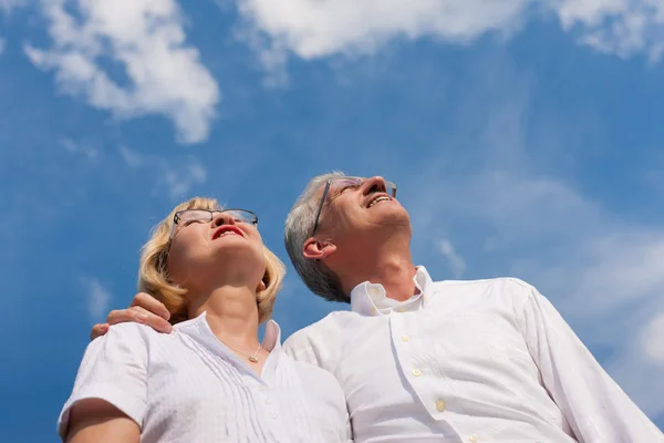 Glückliches älteres Paar blickt in den blauen Himmel — Stockfoto