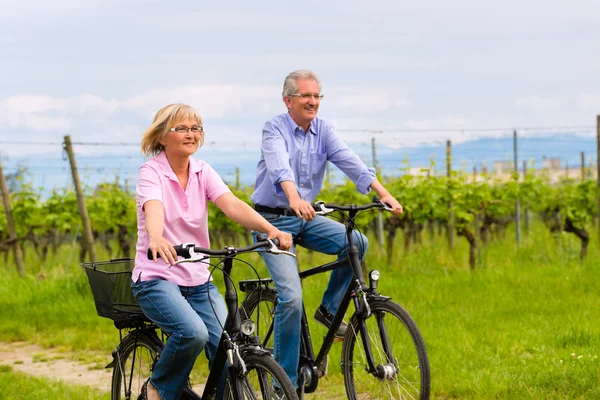 Seniors exercising with bicycle — Stock Photo, Image