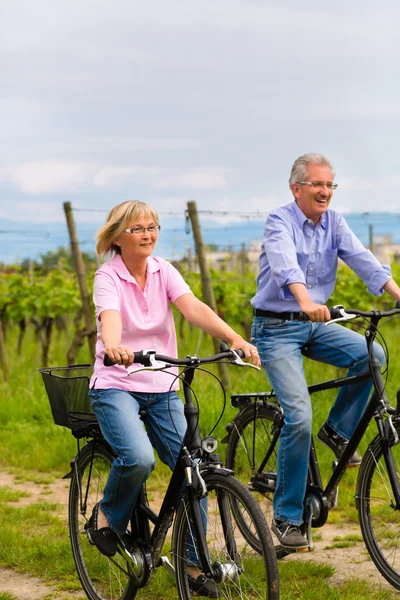 Seniors exercising with bicycle — Stock Photo, Image