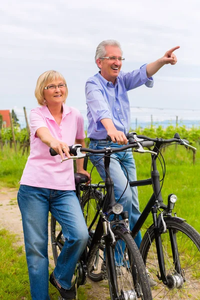 Seniors exercising with bicycle — Stock Photo, Image