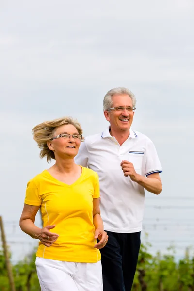 Senioren joggen in der Natur und treiben Sport — Stockfoto